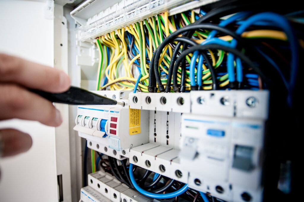 Electrician verificând tabloul electric